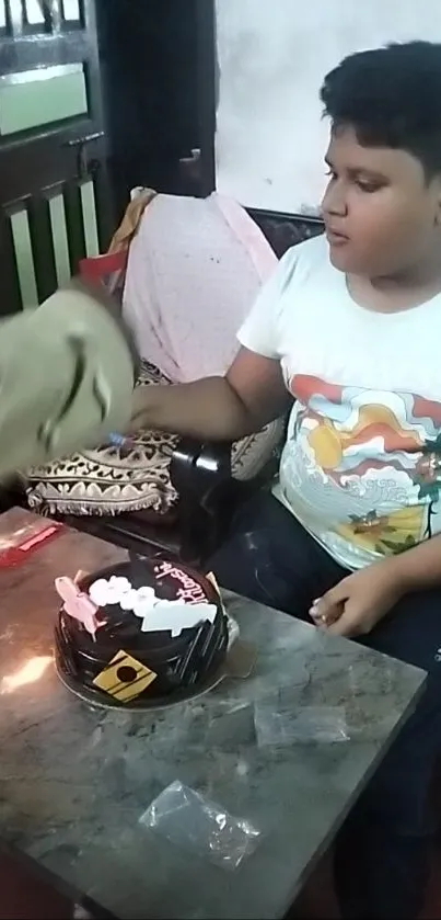 A boy and a cake at a birthday celebration moment.