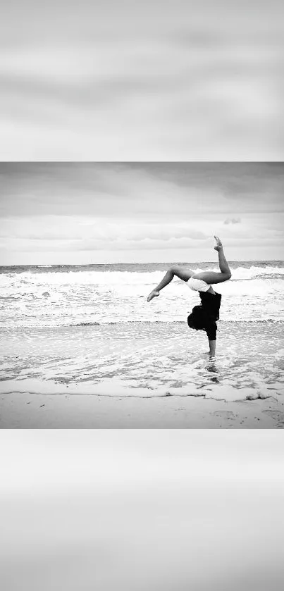 Black and white beach photo with a handstand.