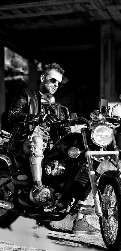 Black and white photo of a biker on a motorcycle wearing a leather jacket.