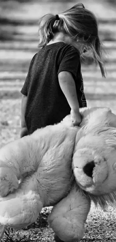 Child carrying giant teddy lion in black and white.