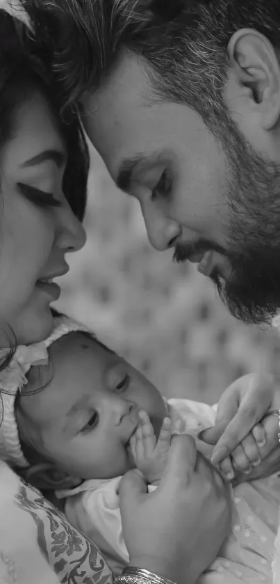 Monochrome family portrait with parents and baby, showcasing love and tenderness.