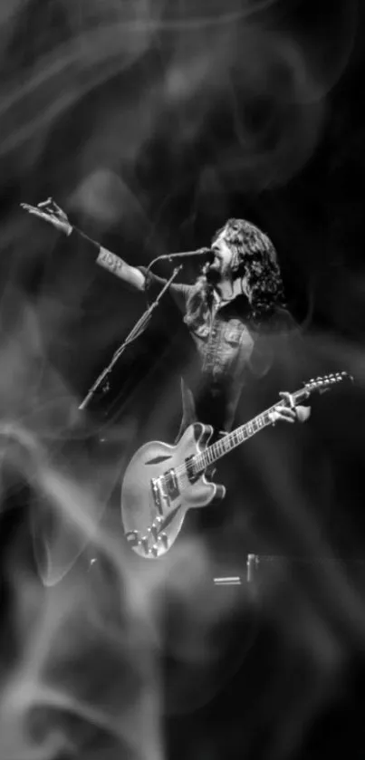 Black and white wallpaper of a guitarist on stage.