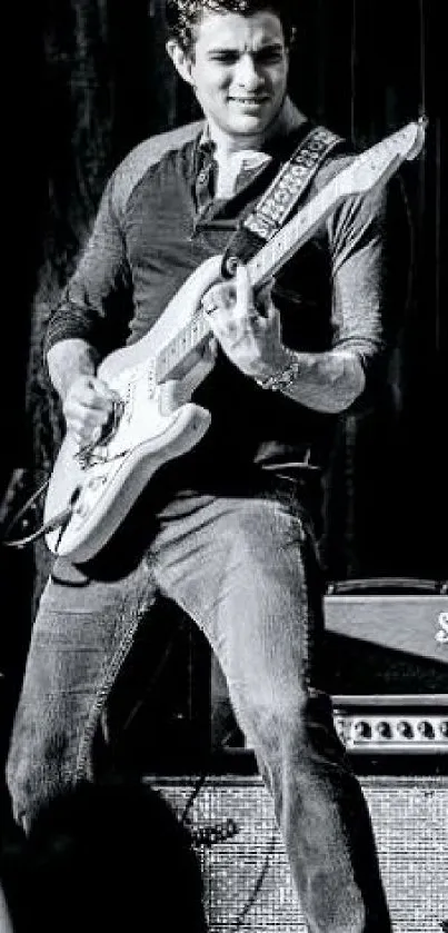 Black and white image of a guitarist on stage playing electric guitar.