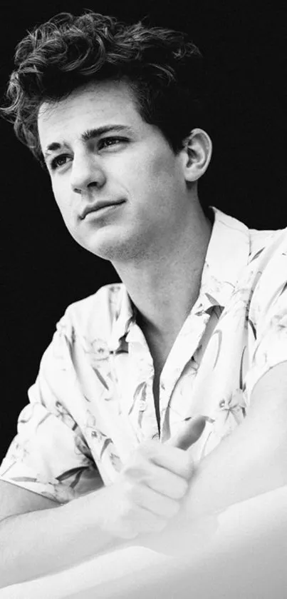 Black and white portrait of a young man in a patterned shirt.