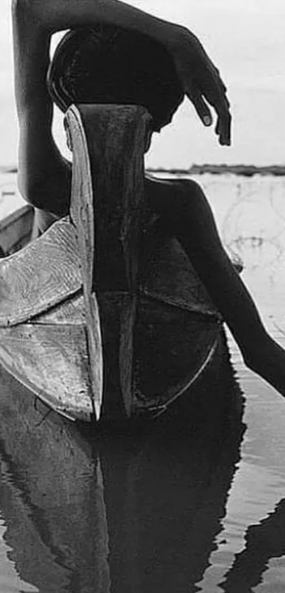 Black and white photo of a person in a canoe on calm water.