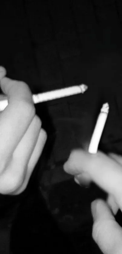 Black and white image of hands holding cigarettes.