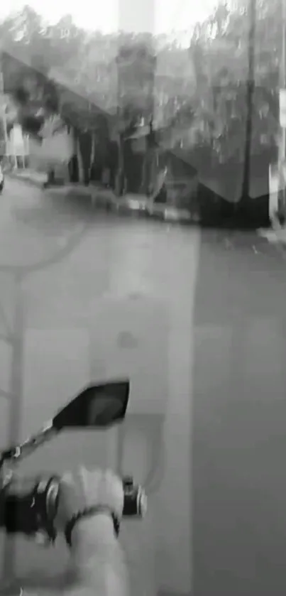 Black and white image of a person riding a motorcycle on an empty street.