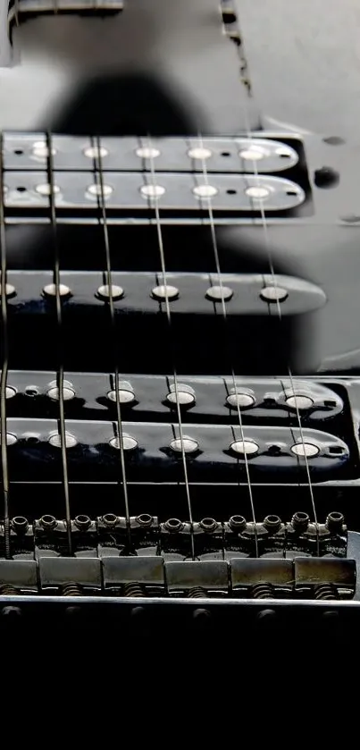 Close-up of black electric guitar strings and body for mobile wallpaper.