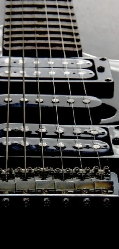 Close-up of a sleek black electric guitar with visible strings and details.