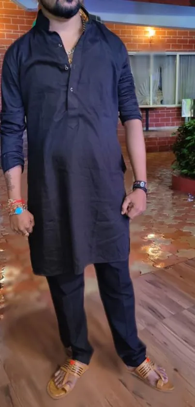 Man wearing black kurta in colorful setting.