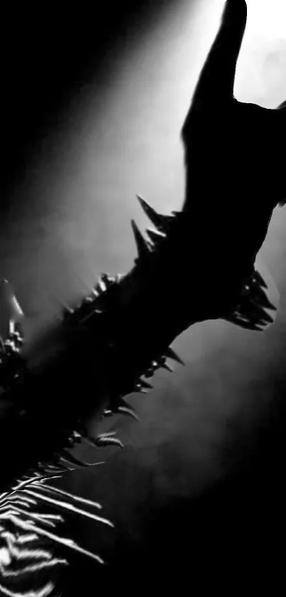 Black metal arm with spikes and rock gesture in spotlight.