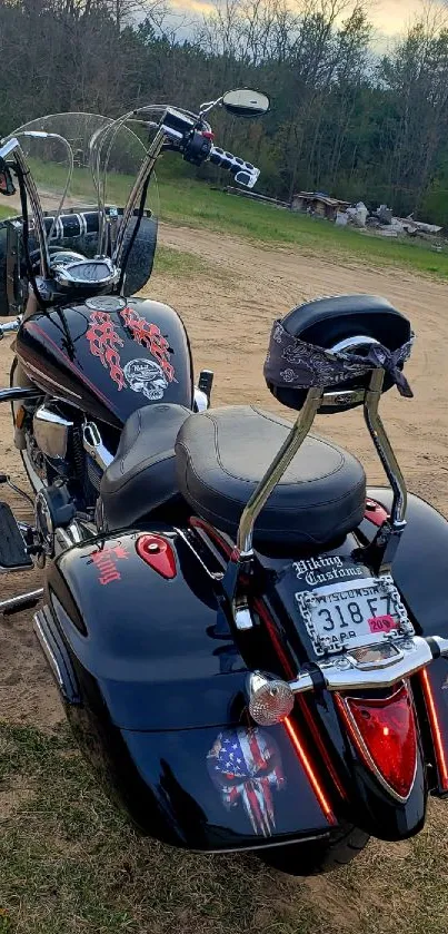 Black motorcycle parked on a sandy dirt road.