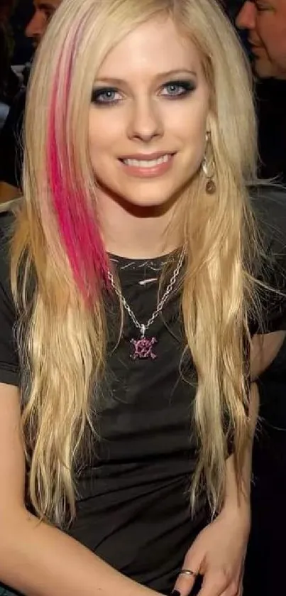 Blonde woman with pink hair streak in a stylish outfit.