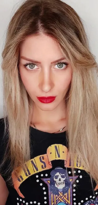 Blonde woman with red lips wearing a graphic T-shirt, posing confidently.