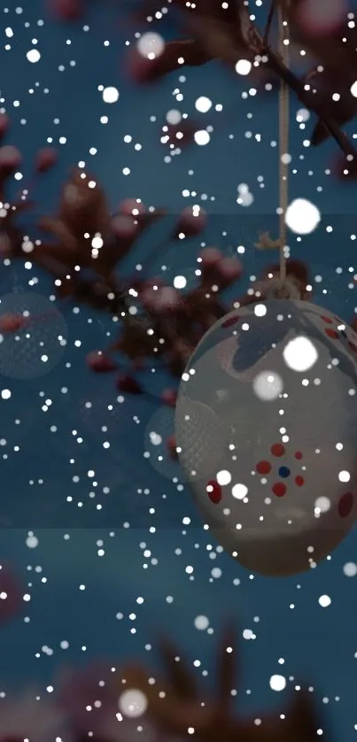 Easter egg hanging from cherry blossom with snowflakes.