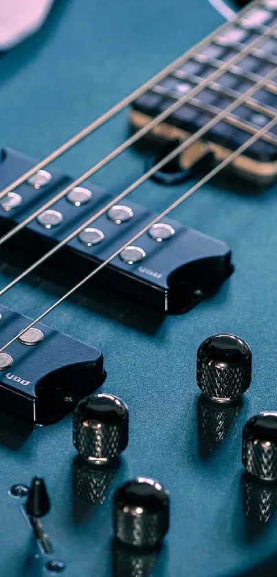 Close-up of a blue electric guitar showing strings and knobs.