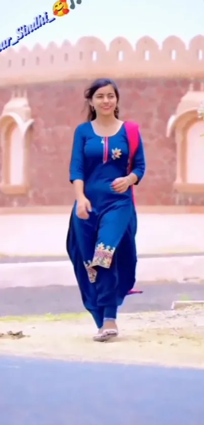 Woman in blue ethnic dress walking, scenic background.