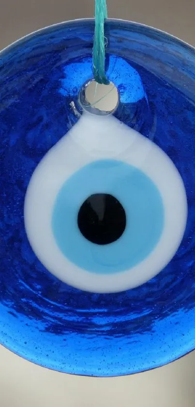 Blue evil eye charm with vibrant hues and circular design.