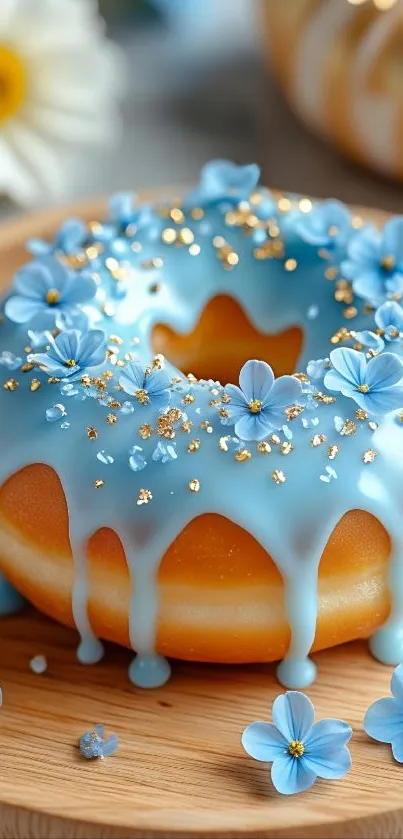 Donut with blue frosting and flowers on wooden plate.
