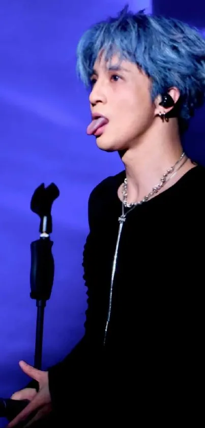 Performer with blue hair on stage in a captivating moment.