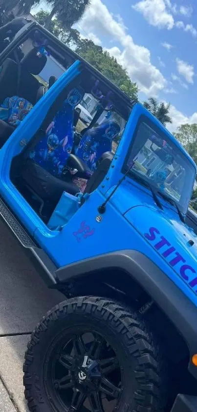 Blue Jeep with open doors under a clear sky.