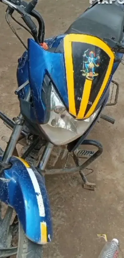 A blue motorcycle with yellow stripes on a dirt surface, ideal for wallpapers.