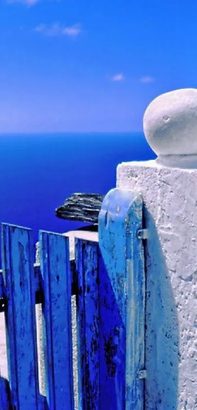 Serene blue ocean view with rustic white gate and clear sky.