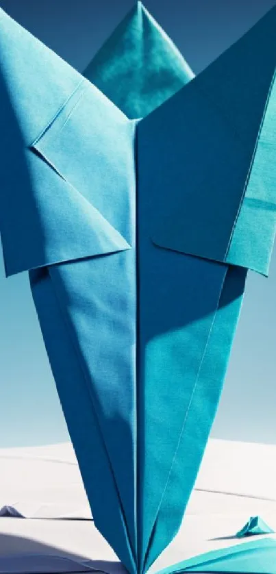 Blue origami flower against sky background, artistic design.