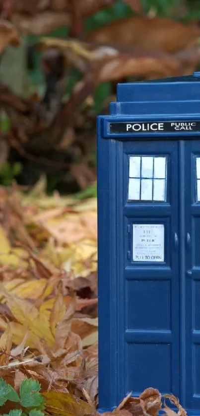 Blue police box amidst autumn leaves background.