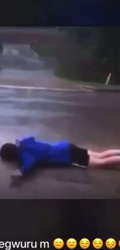 Person in blue jacket lying on wet pavement, enjoying rainy day.