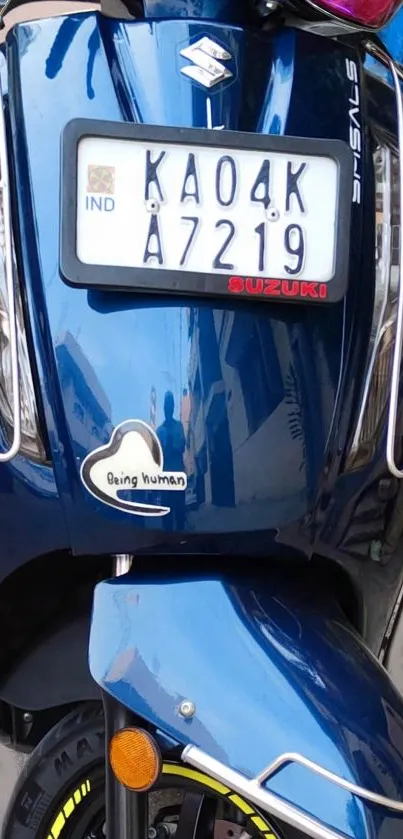 Front view of a blue scooter with chrome accents and a visible license plate.