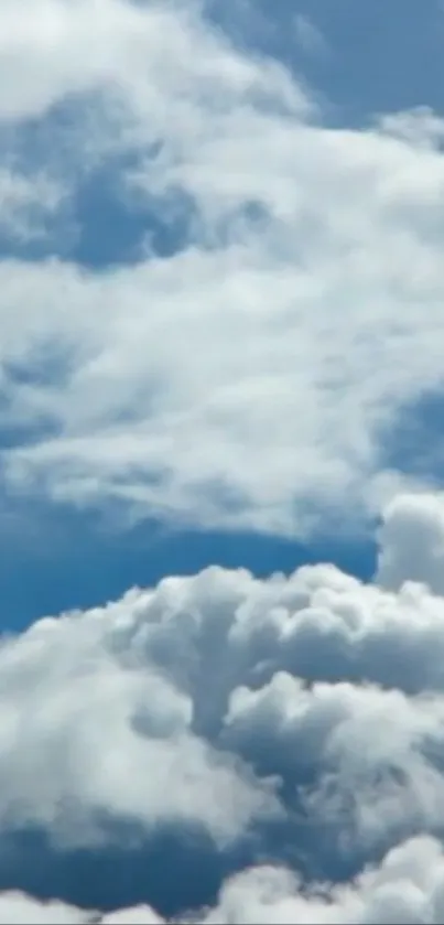 Mobile wallpaper featuring fluffy white clouds against a blue sky.