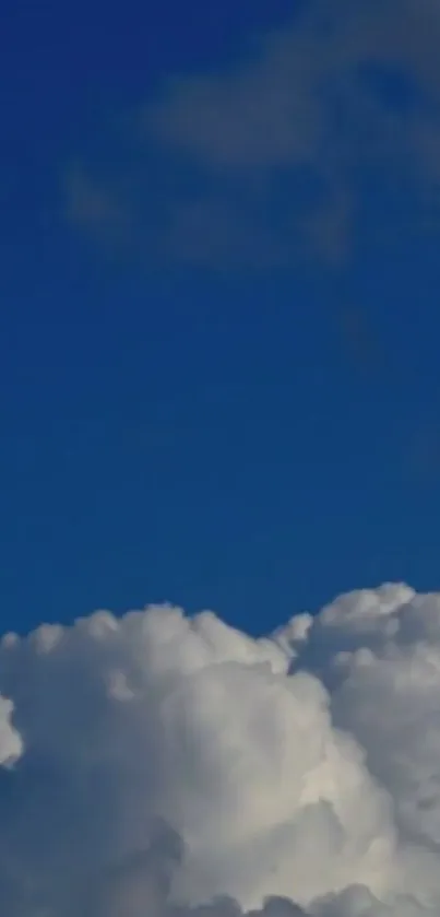 Serene wallpaper of blue sky and fluffy clouds.