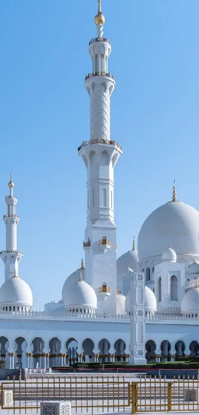 Elegant mosque under clear sky with domes and minarets.