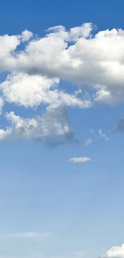 Serene blue sky with fluffy white clouds on a mobile wallpaper.