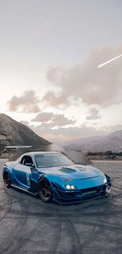 Blue sports car drifting with mountain backdrop at dusk.