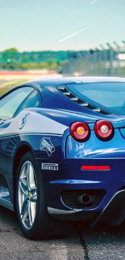 Blue sports car on a racetrack in daylight.