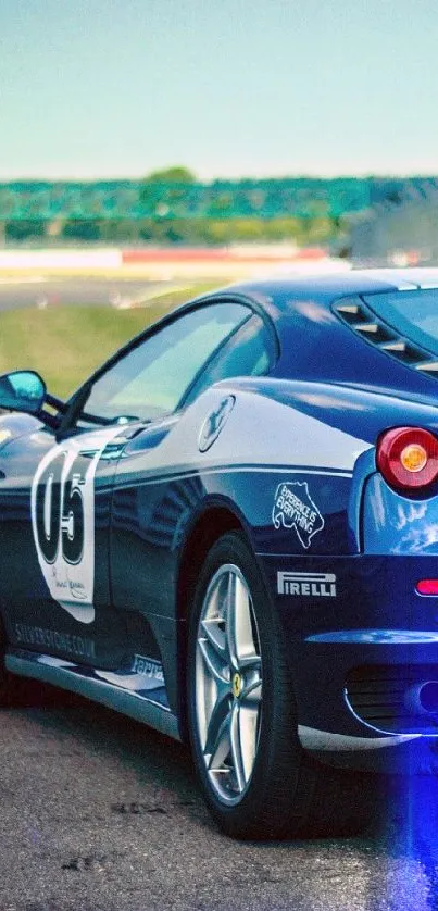 Blue sports car on race track, sleek design.