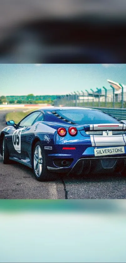 Dynamic blue sports car on race track wallpaper.