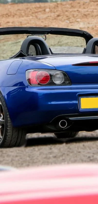 Blue sports car with black interior on road.