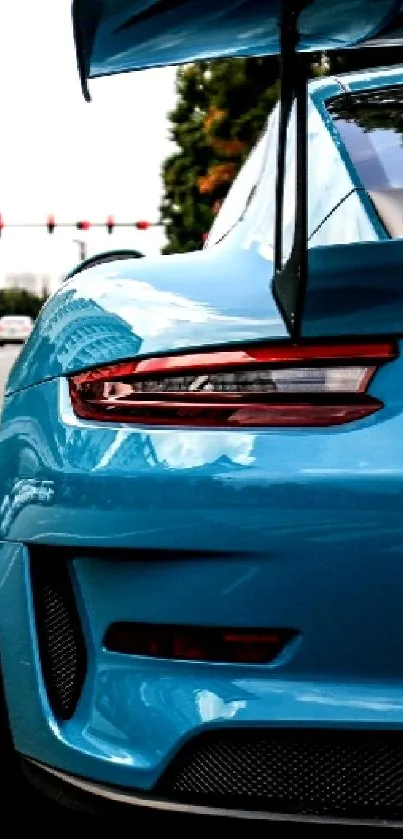 Sleek blue sports car on urban street scene.