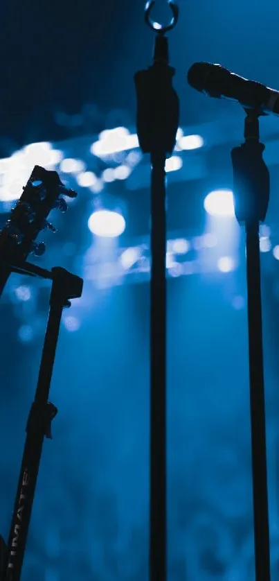 Blue-lit concert stage with guitar and microphone.