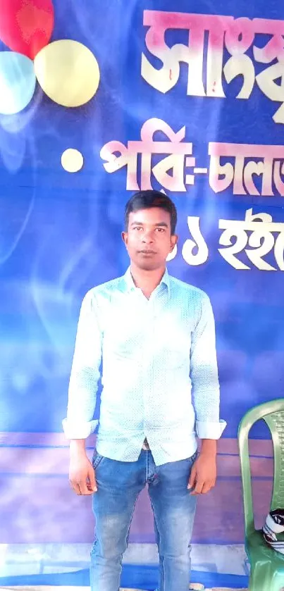 Man standing against blue event backdrop with colorful elements.