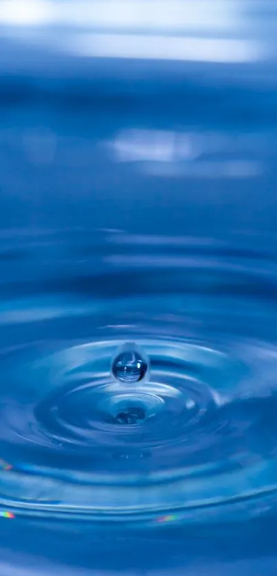 Beautiful blue water droplet creating ripples on a serene surface.