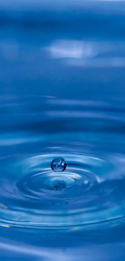 Close-up of a blue water ripple with a droplet in the center.