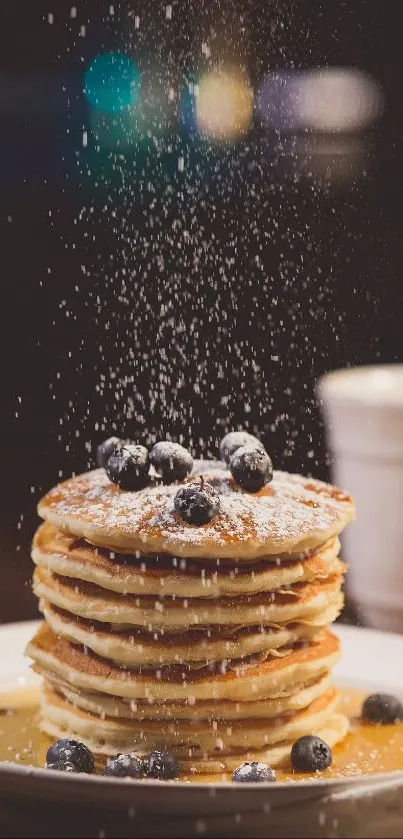 Stack of blueberry pancakes with syrup and powdered sugar.