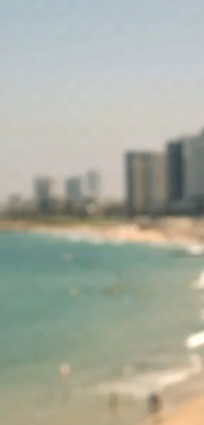 Blurred cityscape and beach with ocean waves under a clear sky.