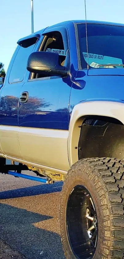 Vibrant blue pickup truck with large tires and rugged design on road.