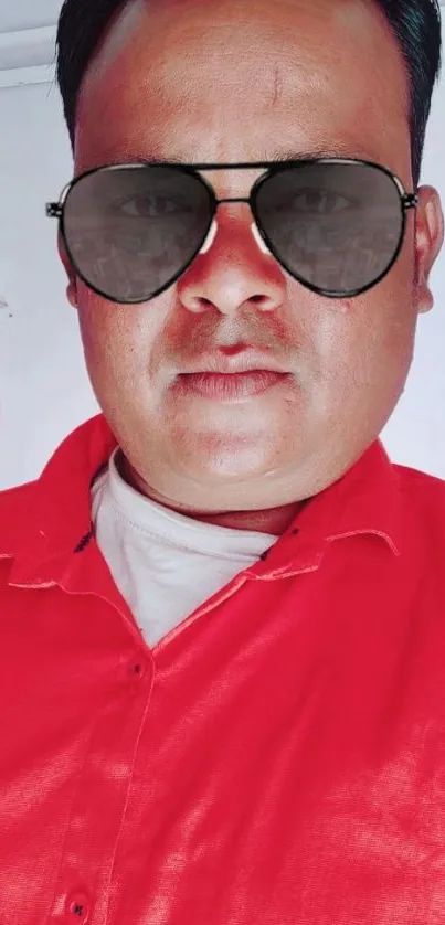 Portrait of a person in a red shirt with sunglasses on.