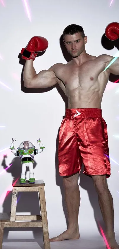 Boxer in red shorts poses with toy on stool against white background.